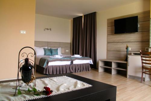 a hotel room with a bed and a table at Garden Guest House in Sandanski