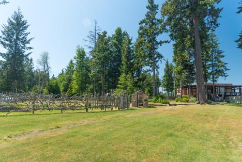 a field with a fence and a house in the background at Ocean Resort in Oyster Bay