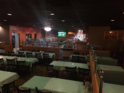 restauracja ze stołami i krzesłami oraz bar w obiekcie Motel 88 w mieście Oneonta