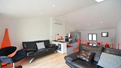 - un salon avec un canapé et des fauteuils en cuir noir dans l'établissement L'Escalier Rouge, à Arles