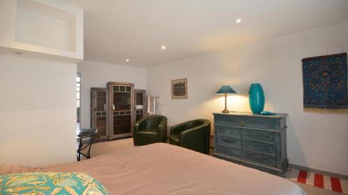 - une chambre avec un lit, deux chaises et une commode dans l'établissement L'Escalier Rouge, à Arles