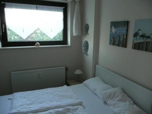 a bedroom with a white bed and a window at Seestern in Dahme