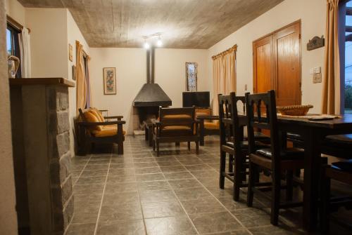 sala de estar con mesa, sillas y chimenea en Casas de la Paloma - BUTIA en La Paloma