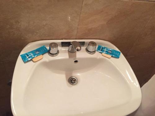 a white sink in a bathroom with two tags on it at Hotel Suipacha in San Miguel de Tucumán