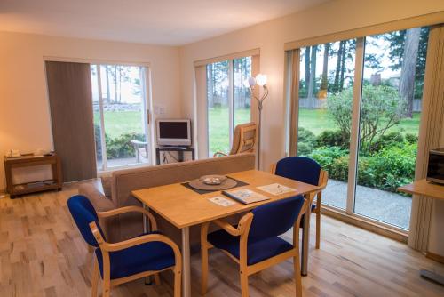 a dining room with a table and chairs and windows at Ocean Resort in Oyster Bay