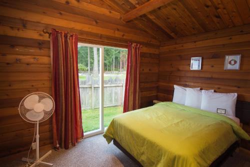 a bedroom with a bed in a log cabin at Ocean Resort in Oyster Bay