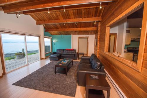 a living room with leather furniture and a view of the ocean at Ocean Resort in Oyster Bay