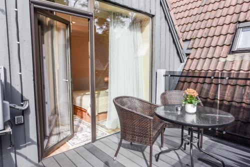 een patio met een tafel en stoelen op een balkon bij Saulės Krantas in Palanga