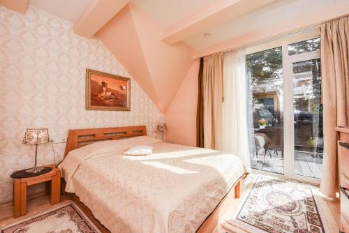 um quarto com uma cama e uma grande janela em Saulės Krantas em Palanga
