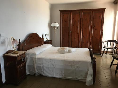 Villa Angelica في فيبو فالينتيا مارينا: غرفة نوم مع سرير مع لوح خشبي للرأس