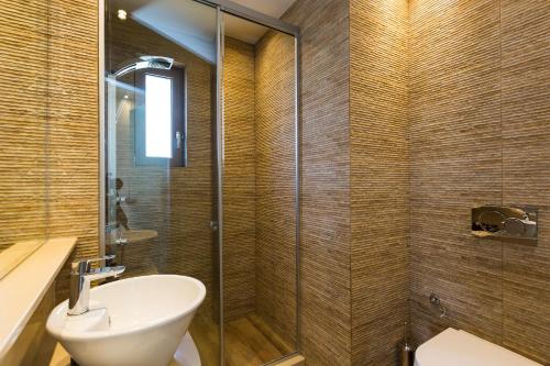 a bathroom with a shower with a sink and a toilet at Aelia Residence, Wellness & Leisure with Heated Pool, By ThinkVilla in Skaleta