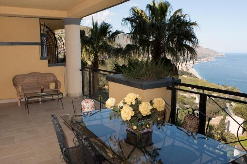 a table on a balcony with a view of the ocean at Taormina SeaView Apartment - Taormina Holidays in Taormina