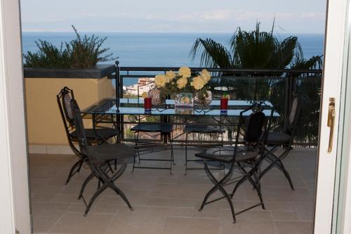 a table and chairs on a balcony with the ocean at Taormina SeaView Apartment - Taormina Holidays in Taormina