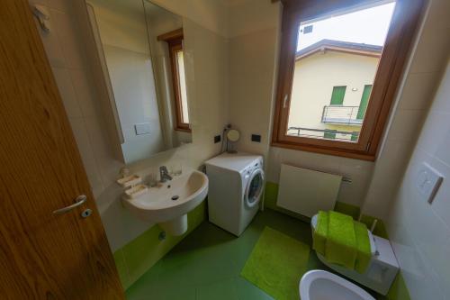 een badkamer met een wastafel, een toilet en een spiegel bij Residence degli Oleandri 4B in Argegno
