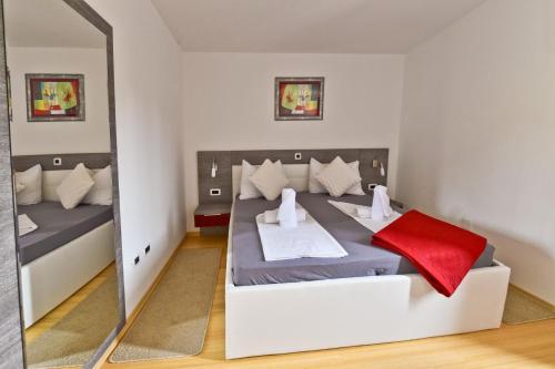 sypialnia z łóżkiem i lustrem w obiekcie Apartmani Astrado Petrčane w Petrčane