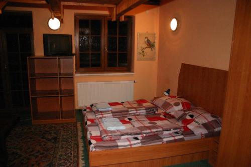 1 dormitorio con 1 cama y TV en Penzion Pohoda, en Luleč