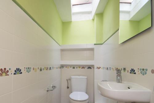 a bathroom with a white toilet and a sink at La Caseta del Priorat in Porrera