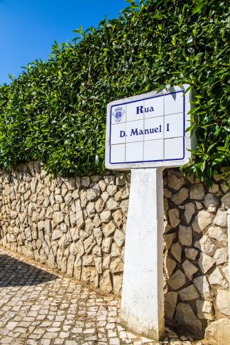 a street sign in front of a stone wall at Casas Novas Guesthouse - Adults Only in Lagos