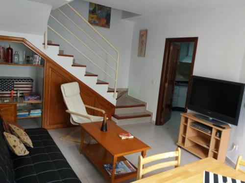 ein Wohnzimmer mit einer Treppe und einem TV in der Unterkunft Casa Amaia in Arrecife