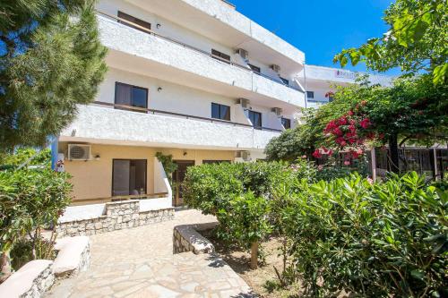 an external view of a building with trees and bushes at Voula Studios in Faliraki