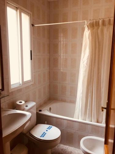 a bathroom with a toilet and a tub and a sink at Hospedium Hotel Twist in Torredonjimeno