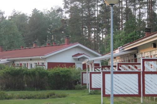 a house with a red roof and a street light at Visit Hautakylä in Hautakylä