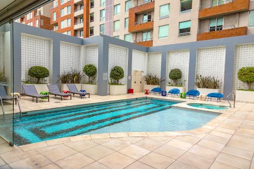 una gran piscina con sillas y un edificio en Park Inn San Jose by Radisson, en San José