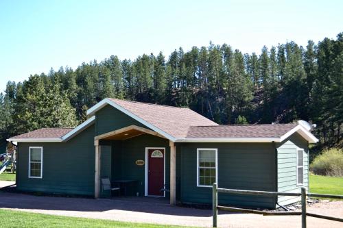 a green tiny house with a red door at Black Elk Resort in Hill City