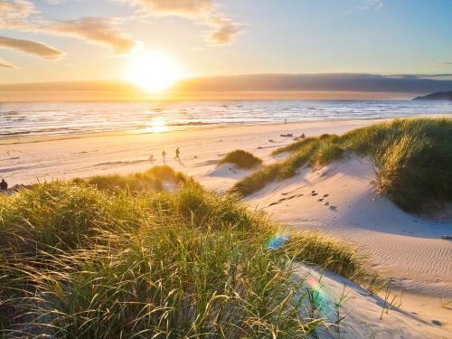 a sunset over a beach with the ocean at Ocean Shores Resort in Ocean Shores