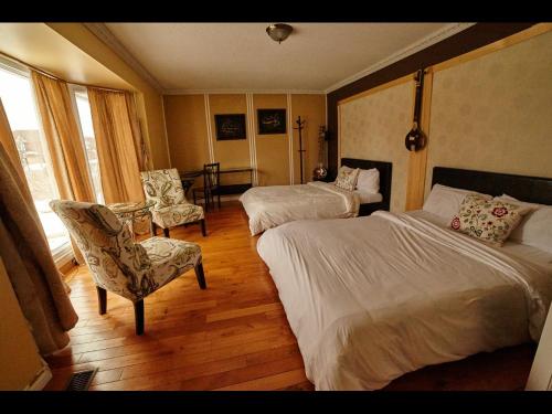 
a hotel room with a bed, chair, and a window at Mac B&B in Ottawa
