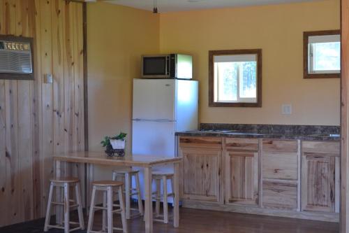 a kitchen with a white refrigerator and a table with stools at Black Elk Resort in Hill City