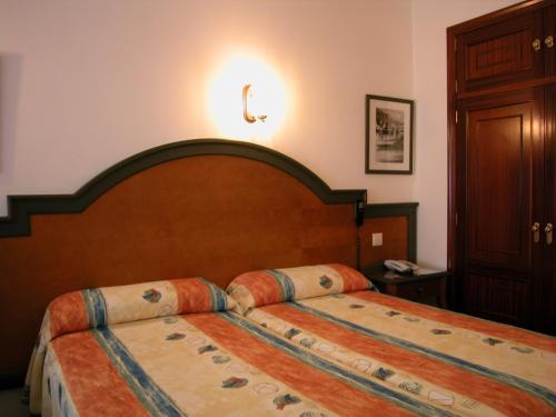Ένα ή περισσότερα κρεβάτια σε δωμάτιο στο Hotel Touris
