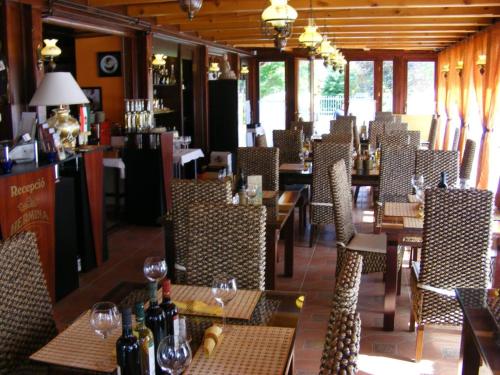 a restaurant with tables and chairs with wine bottles at Hermina Panzió in Siófok