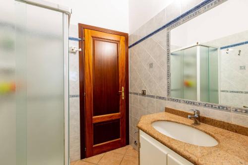 a bathroom with a sink and a glass door at Villetta San Teodoro in San Teodoro