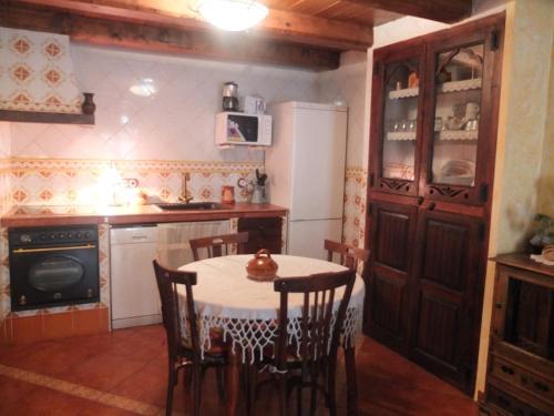 uma cozinha com uma mesa com cadeiras e um frigorífico em Casa Gómez em Mosqueruela