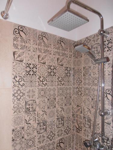 a shower with a patterned shower curtain in a bathroom at Elli Beach Apartments and Studios in Almiros Beach