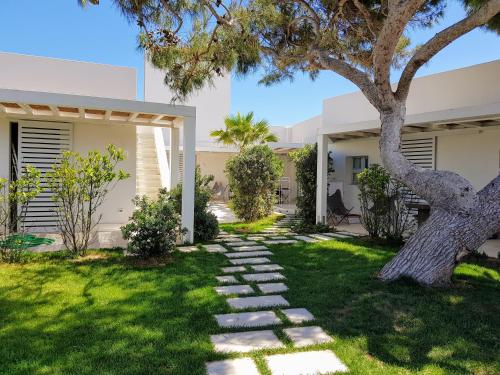 einen Garten mit einem Baum und einem Steinweg in der Unterkunft Casa Mirella in Favignana