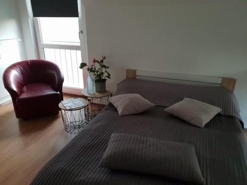 1 dormitorio con 2 camas, silla y ventana en Gemütliches Zimmer mit eigenem Bad/WC/Küche, en Kassel