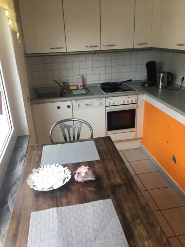 a kitchen with a wooden table with a plate on it at Gemütliches Zimmer mit eigenem Bad/WC/Küche in Kassel