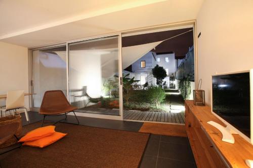a living room with a large window and a television at Place Of Moments Urban-Suites in Ponta Delgada