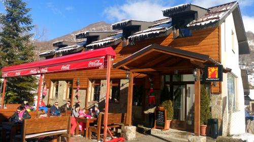 un restaurante con gente sentada fuera de un edificio en Mountain house Campari, en Mavrovo