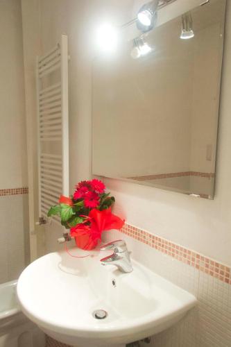 a bathroom with a sink with a red flower on it at WINE & LAKE IN FRANCIACORTA in Passirano