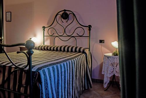 a bedroom with a bed with a blue and white blanket at Cascina San Bernardo in Magliano Alfieri
