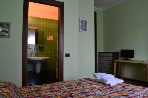 a bedroom with a bed and a sink and a bathroom at B&B Orio BGY in Orio al Serio