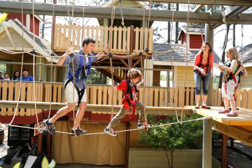 a group of people on a ropes course in a playground at Atlanta Evergreen Lakeside Resort in Stone Mountain