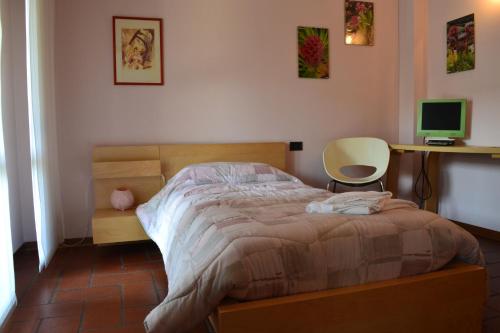 Schlafzimmer mit einem Bett, einem Schreibtisch und einem Computer in der Unterkunft B&B Orio BGY in Orio al Serio