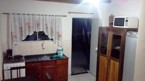 a kitchen with a sink and a microwave at Hospedagem 3 Estrelas in Navegantes