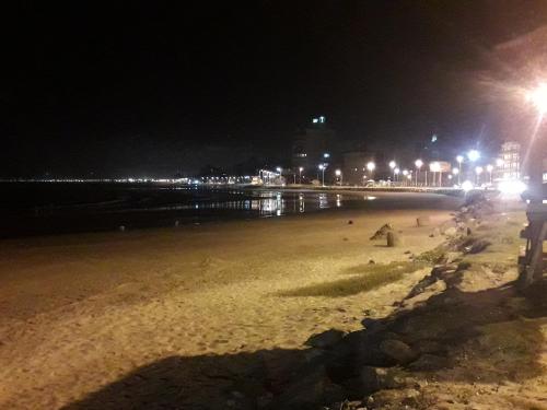 a beach at night with people on the beach at Hospedagem 3 Estrelas in Navegantes