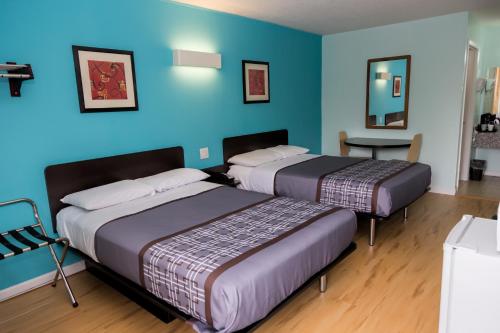 two beds in a room with blue walls at Relax Inn Front Royal in Front Royal