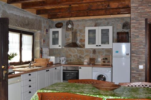a kitchen with white cabinets and a white refrigerator at Casa de Sao Joao in Gandarela